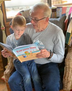 Pops reading Jax the book Everyone Dies